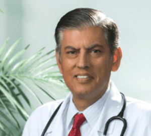 A man in white lab coat and red tie.