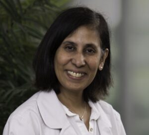 A woman in white shirt smiling for the camera.